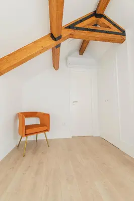 a chair in an empty room with a wooden ceiling at Vibrant Host - Heroismo's Metro in Porto