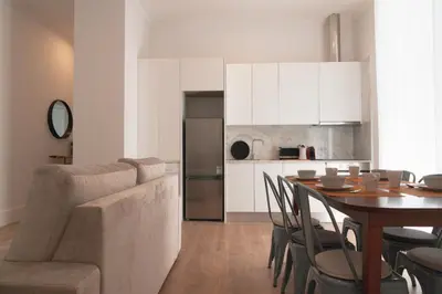 a living room and kitchen with a table and a couch at Vibrant Host - Heroismo's Metro in Porto