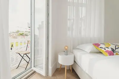 a small bedroom with a bed and a glass window at Vibrant Host - Heroismo's Metro in Porto