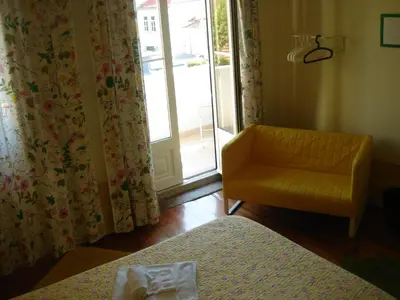 a bedroom with a bed and a chair and a window at CoolHostel in Porto