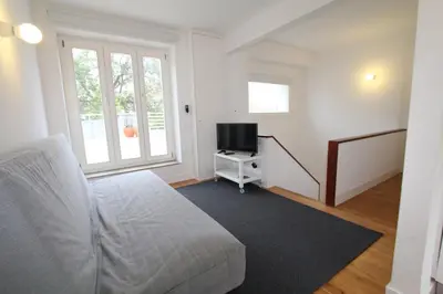 a living room with a bed and a tv at OPO.APT - Art Deco Apartments in Oporto's Center in Porto