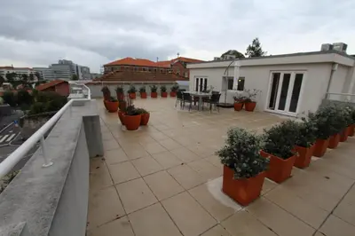a balcony with potted plants on top of a building at OPO.APT - Art Deco Apartments in Oporto's Center in Porto