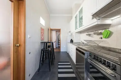 a kitchen with white cabinets and a stove top oven at LovelyStay - The Porto Getaway Duplex - Free Parking in Porto