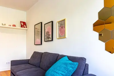 a living room with a blue couch and paintings on the wall at Guest H4U - Porto Batalha City Center in Porto