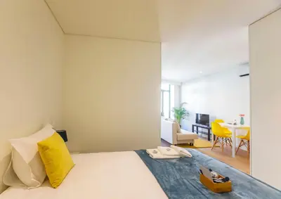 a bedroom with a bed with a yellow pillow at Oliveira Apartment`s in Porto