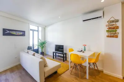 a living room with a white couch and a table at Oliveira Apartment`s in Porto