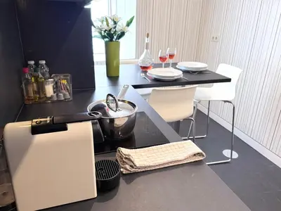 a kitchen with a counter with a table and chairs at Ribeira Cinema Apartments in Porto