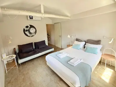 a bedroom with a large white bed and a couch at Ribeira Cinema Apartments in Porto