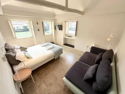 a bedroom with a large bed and a couch at Ribeira Cinema Apartments in Porto