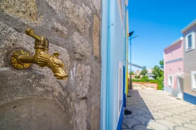 a brass faucet on a stone wall at Maredimo Village Porto Casa 2 in Porto