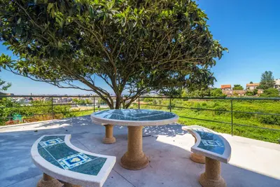 a table and two benches in front of a tree at Maredimo Village Porto Casa 2 in Porto