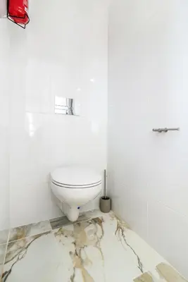 a white toilet in a bathroom with a marble floor at Maredimo Village Porto Casa 2 in Porto