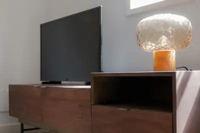 a lamp on top of a entertainment center with a television at Nomad's By Sta Catarina Flats - 3BED Porto in Porto