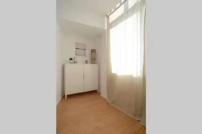 a white room with a window and a wooden floor at Softly Porto in Porto