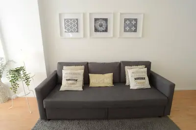 a gray couch in a living room with pillows at Softly Porto in Porto