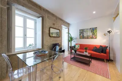 a living room with a red couch and a table at LovelyStay - Vitoria Viewpoint 1BR Flat in Porto