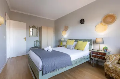 a bedroom with a large bed and a chair at MyRiverPlace N 4 Private Terrace River View Porto apartments in Vila Nova de Gaia