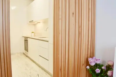 a kitchen with a vase of pink roses in a room at OHH - Caldeireiros Luxury Apartments in Porto
