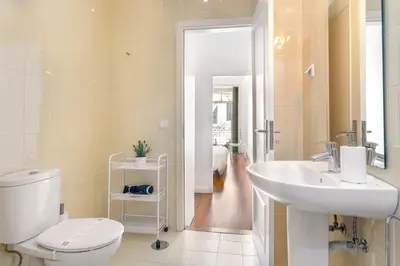 a bathroom with a white toilet and a sink at Hungarian Biscuit Apartment in Porto