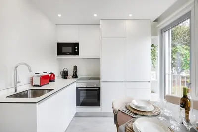 a living room with a white couch and a balcony at Modern Studio @ Palácio de Cristal in Porto