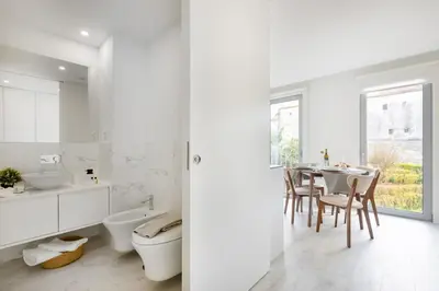 a white kitchen with a sink and a table at Modern Studio @ Palácio de Cristal in Porto