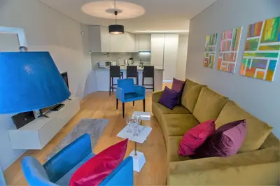 a living room with a couch and blue chairs at Premium Style Apt by Porto City Hosts in Porto