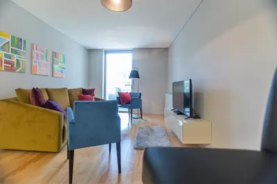 a living room with a couch and a television at Premium Style Apt by Porto City Hosts in Porto