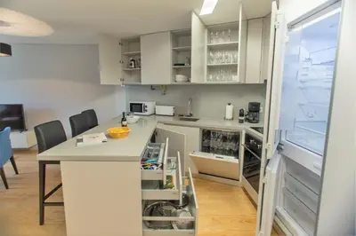 a kitchen with white cabinets and a large window at Premium Style Apt by Porto City Hosts in Porto