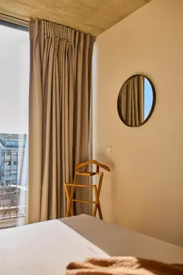 a bedroom with a bed and a mirror and a window at Oporto Maison Anselmo in Porto