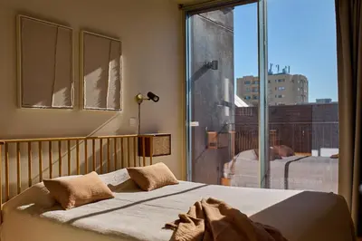 a bedroom with a bed and a large window at Oporto Maison Anselmo in Porto