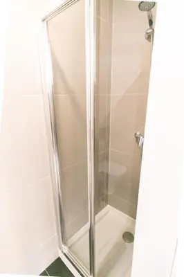 a shower with a glass door in a bathroom at Design Boavista Music Apartments in Porto