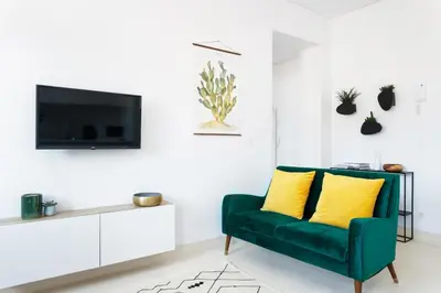 a living room with a green couch and a tv at Oporto Amazing View Apartment in Porto