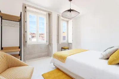 a white bedroom with a bed and a chair at Oporto Amazing View Apartment in Porto