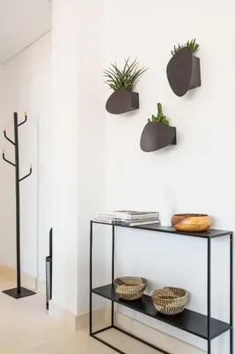 a black console table with plants on a white wall at Oporto Amazing View Apartment in Porto
