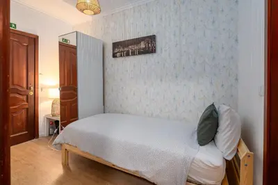 a bedroom with a large bed and a living room at Renovated Feb25 Clerigos Cozy Balcony with self check in in Porto
