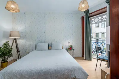 two pillows sitting on a bed next to a table at Renovated Feb25 Clerigos Cozy Balcony with self check in in Porto