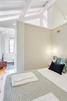 a bedroom with a large bed in a white room at DA'HOME - Rola Art Work Studio in Porto
