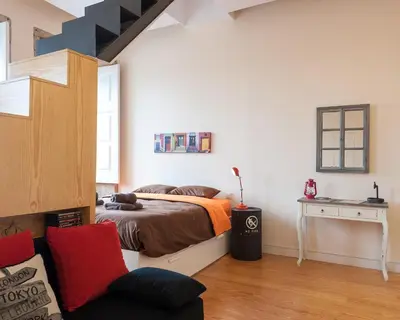 a bedroom with a bed and a chair in a room at Studio with terrace @ historic center in Porto