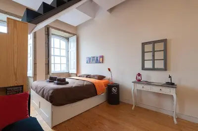 a bedroom with a large bed and a desk at Studio with terrace @ historic center in Porto