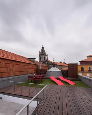 a wooden deck with red benches and a tent at Studio with terrace @ historic center in Porto