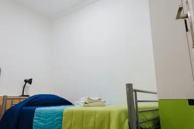 a room with a bed with a green blanket on it at House Romantic R/C left in Porto