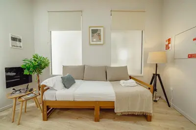 a bedroom with a bed and two windows at A Portuense in Porto