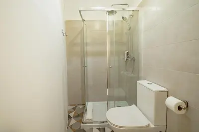 a bathroom with a toilet and a glass shower at A Portuense in Porto