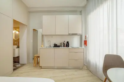 a kitchen with white cabinets and a table and chairs at A Portuense in Porto
