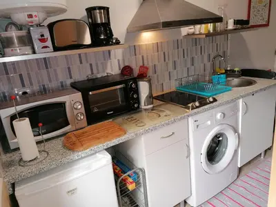 a kitchen with a microwave and a washing machine at House Romantic R/C Right in Porto