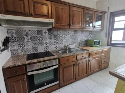 a kitchen with wooden cabinets and a sink at Coronel Pacheco 42 - Porto in Porto