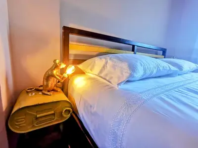 a bed with a toy frog sitting on a suitcase at Coronel Pacheco 42 - Porto in Porto