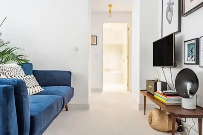 a living room with a blue couch and a table at Decompress at a Tranquil, Minimal Urban Oasis with an Edge in Porto