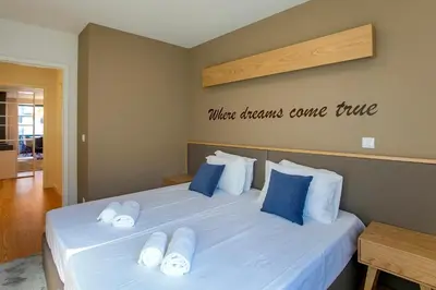 a bedroom with a white bed with blue pillows at Chic Alves Apartment in Porto