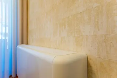 a white object is against a brick wall at Chic Alves Apartment in Porto